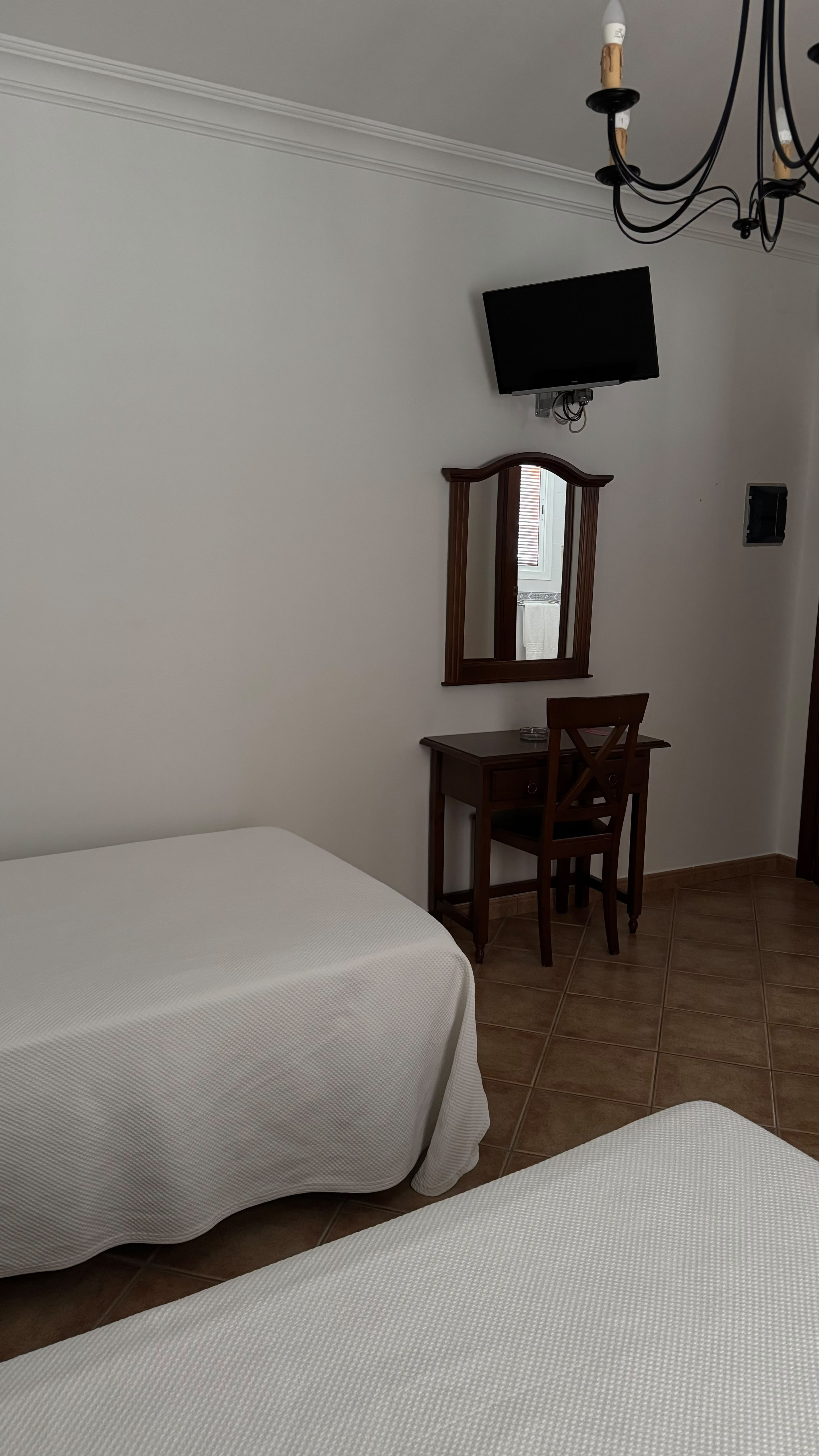 Detalle de escritorio y TV en habitación de Hostal Santa Cruz